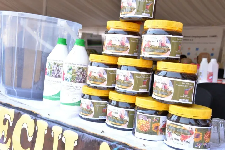 Stacked jars of Nectartrin Honey and bottles of HINGA WEZE on an exhibition table