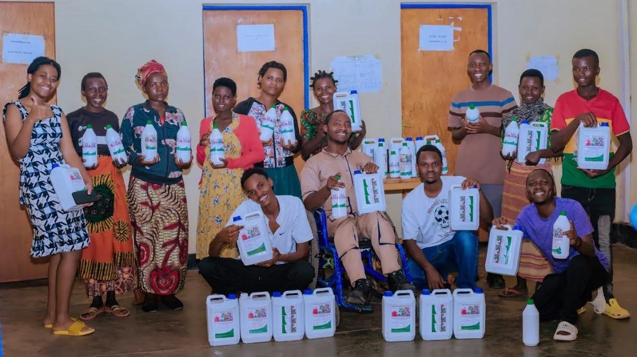 Young farmers smiling and holding containers of HINGA WEZE
